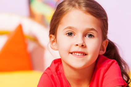 Close portrait of smiling little girl with subtle smile look at camera